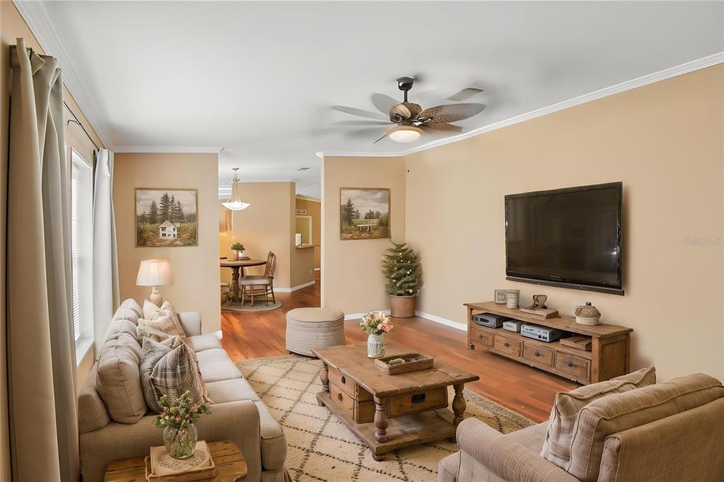 A living room features a beige sofa, wooden coffee table, television, and hardwood floors — 6221 EMERSON ROAD, BROOKSVILLE, FL