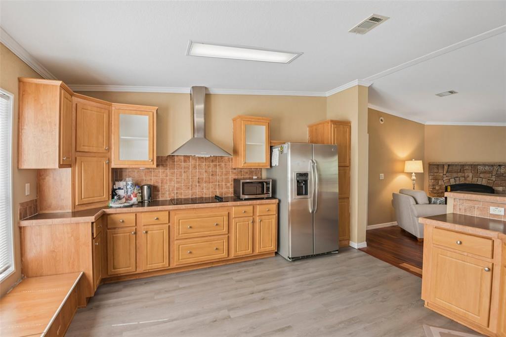 A kitchen with light wood cabinets, stainless steel appliances, and a tiled backsplash — 6221 EMERSON ROAD, BROOKSVILLE, FL
