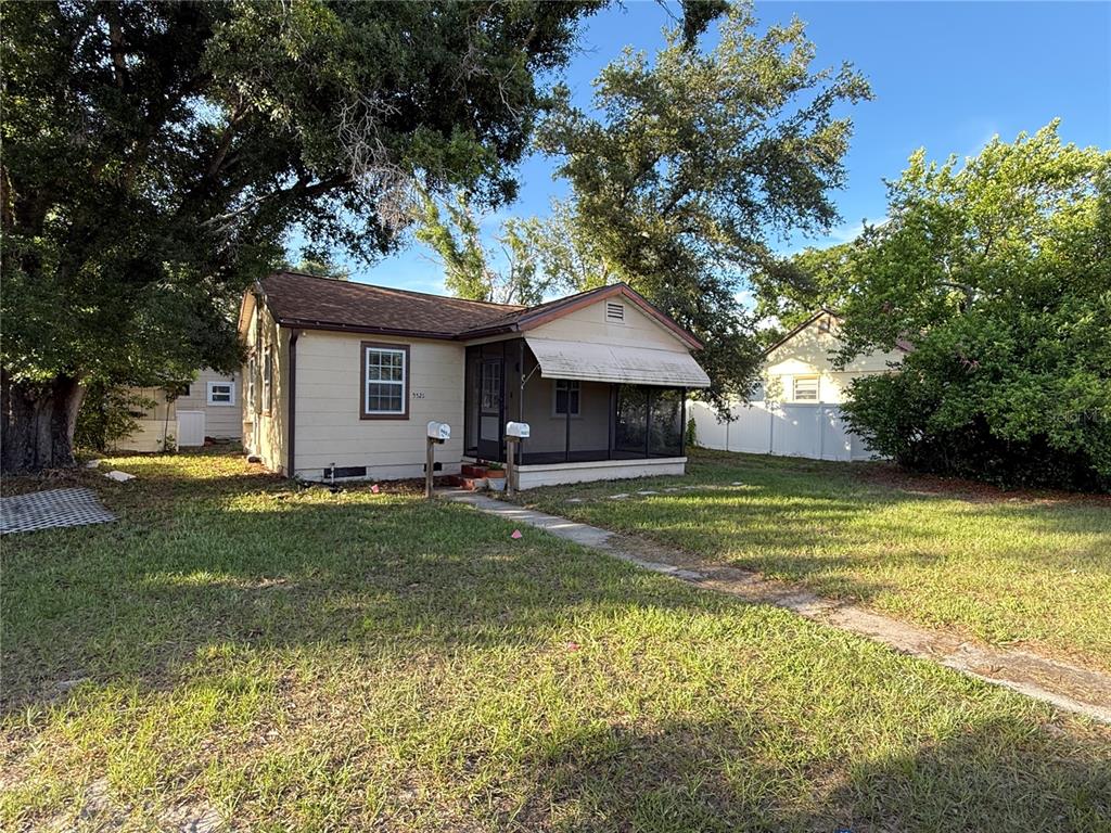 A single-story house with a screened-in front porch and a large front yard — 5521 5TH AVENUE N, ST PETERSBURG, FL