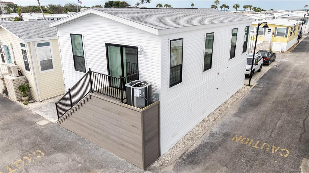 An exterior view of a white mobile home with a front deck and AC unit — 3710 GULF OF MEXICO DRIVE UNIT F2, LONGBOAT KEY, FL