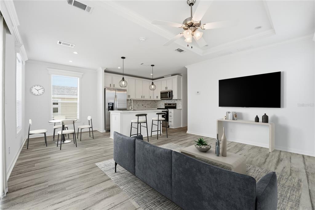 An open-concept living room and kitchen with white cabinets, stainless appliances, and wood-look flooring — 3710 GULF OF MEXICO DRIVE UNIT F2, LONGBOAT KEY, FL