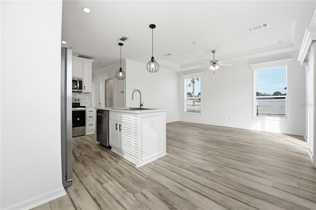 A kitchen with a white island and stainless steel appliances opens into a living area — 3710 GULF OF MEXICO DRIVE UNIT F2, LONGBOAT KEY, FL
