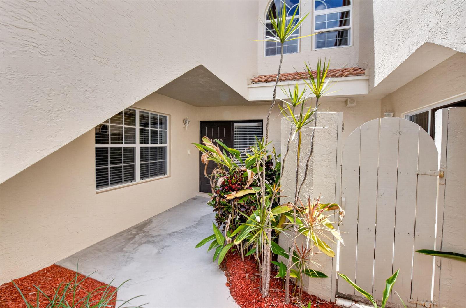 The exterior entrance features a concrete walkway, a wooden gate, and a small garden bed — 17276 Boca Club Boulevard # 1805, Boca Raton FL 33487, BOCA RATON, FL