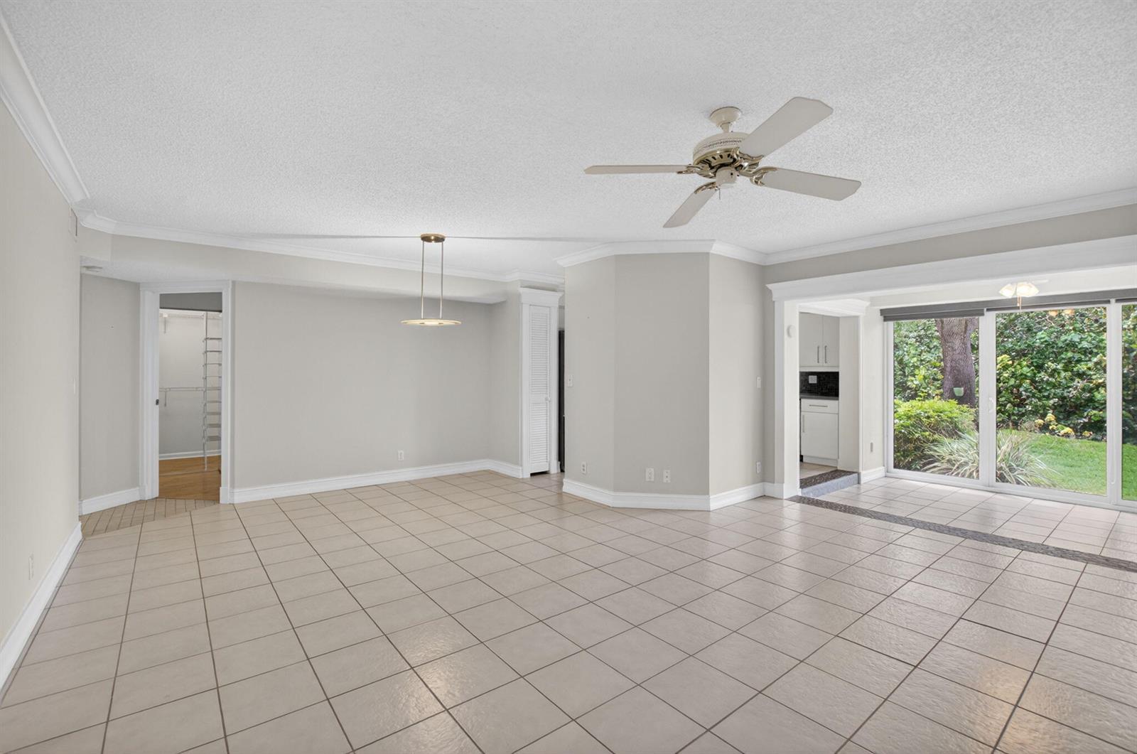 An open living area with beige tile flooring, a ceiling fan, and sliding glass doors — 17276 Boca Club Boulevard # 1805, Boca Raton FL 33487, BOCA RATON, FL