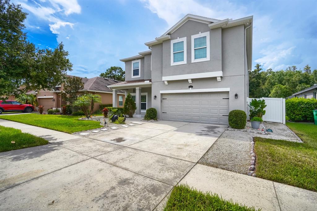A two-story gray house with a two-car garage and a concrete driveway — 3951 PACENTE LOOP, WESLEY CHAPEL, FL