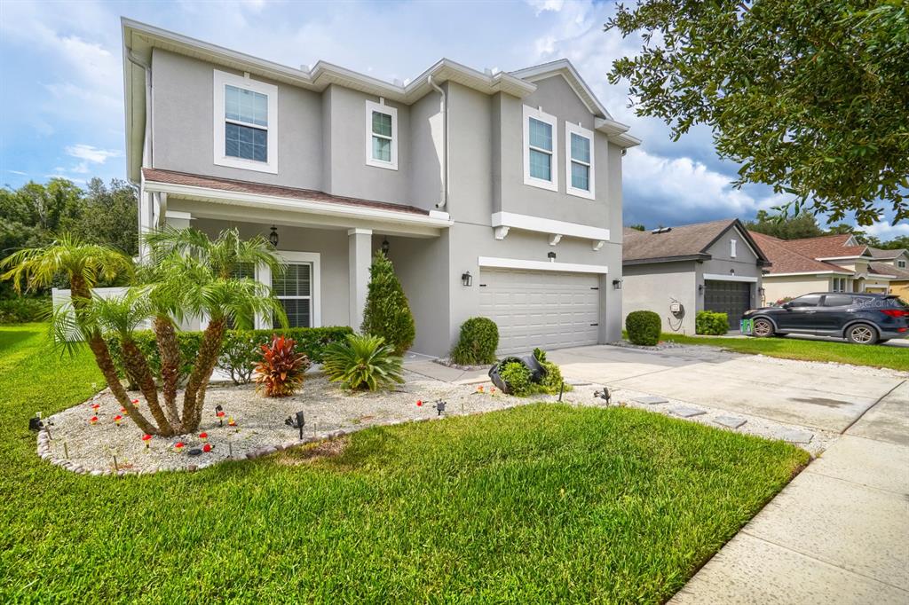 A two-story gray house with a two-car garage and a landscaped front yard — 3951 PACENTE LOOP, WESLEY CHAPEL, FL