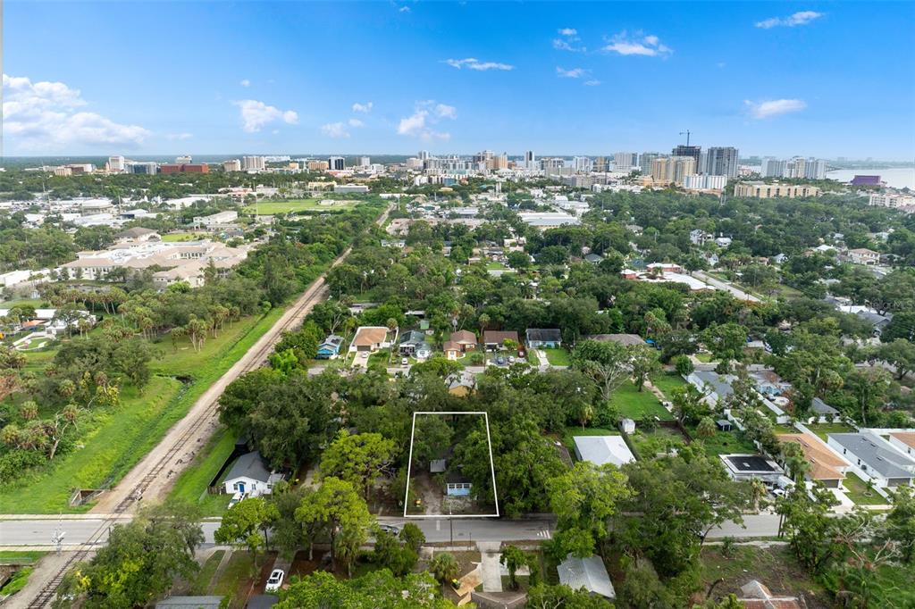 An aerial view shows a small house on a wooded lot near railroad tracks — 1468 19TH STREET, SARASOTA, FL