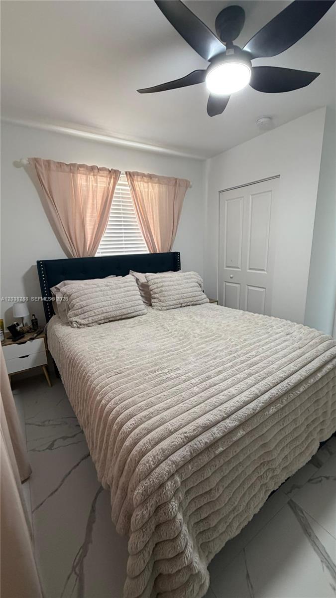A bedroom features a dark upholstered headboard, a textured beige bedspread, and a ceiling fan — 4161 NE 17th Ave, Pompano Beach FL 33064, POMPANO BEACH, FL