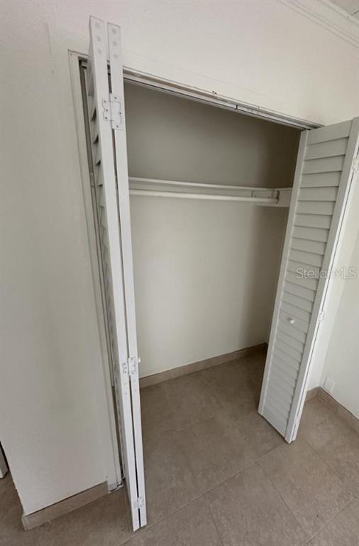 A closet with white louvered bifold doors, a hanging rod, and a shelf — 1238 HERSCHELL STREET, LAKELAND, FL