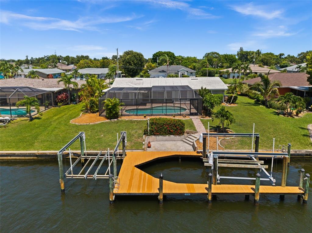 An aerial view of a waterfront house with a pool, screened lanai, and private dock — 4102 SE 1ST PLACE, CAPE CORAL, FL