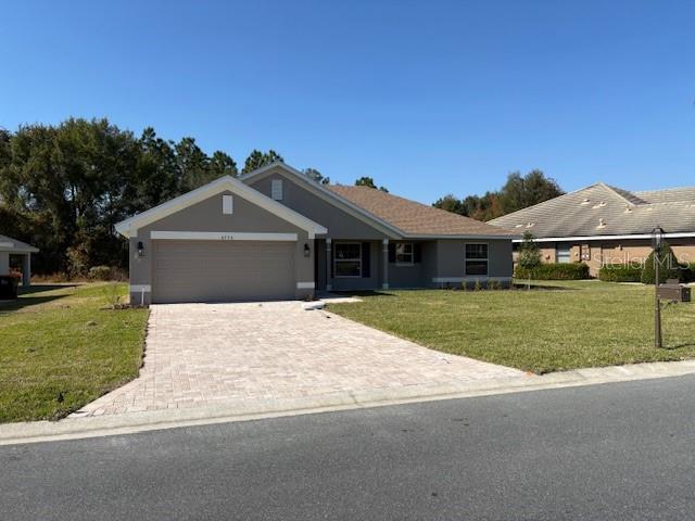 A single-story house with a gray exterior, a paved driveway, and a two-car garage — 6770 SW 179TH AVENUE ROAD, DUNNELLON, FL