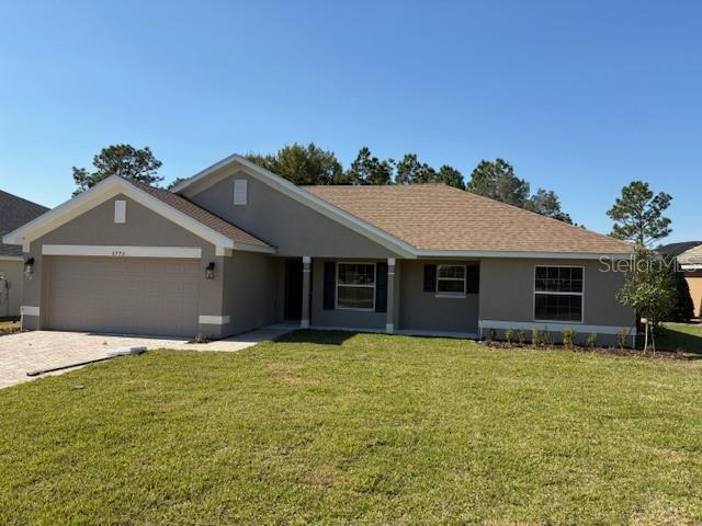 A single-story house with a tan exterior, a two-car garage, and a brown shingled roof — 6770 SW 179TH AVENUE ROAD, DUNNELLON, FL