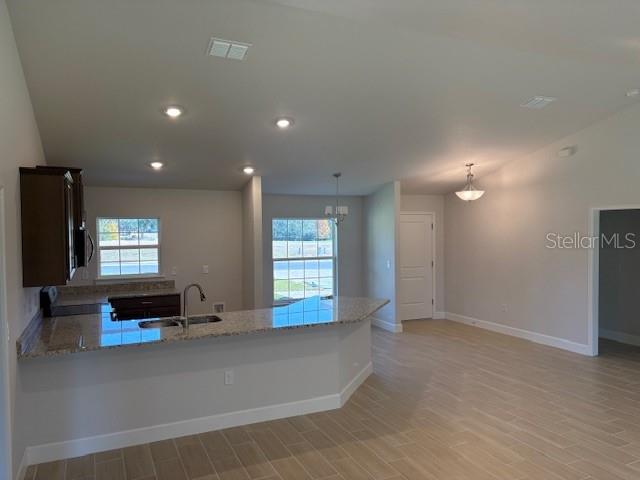 A kitchen with a granite breakfast bar, light-colored walls, and wood-look tile flooring — 6770 SW 179TH AVENUE ROAD, DUNNELLON, FL