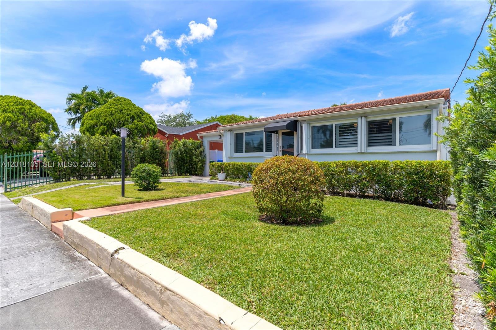 A single-story house with a white exterior, a tiled roof, and a manicured front lawn — 3151 NW Flagler Ter, Miami FL 33125, MIAMI, FL