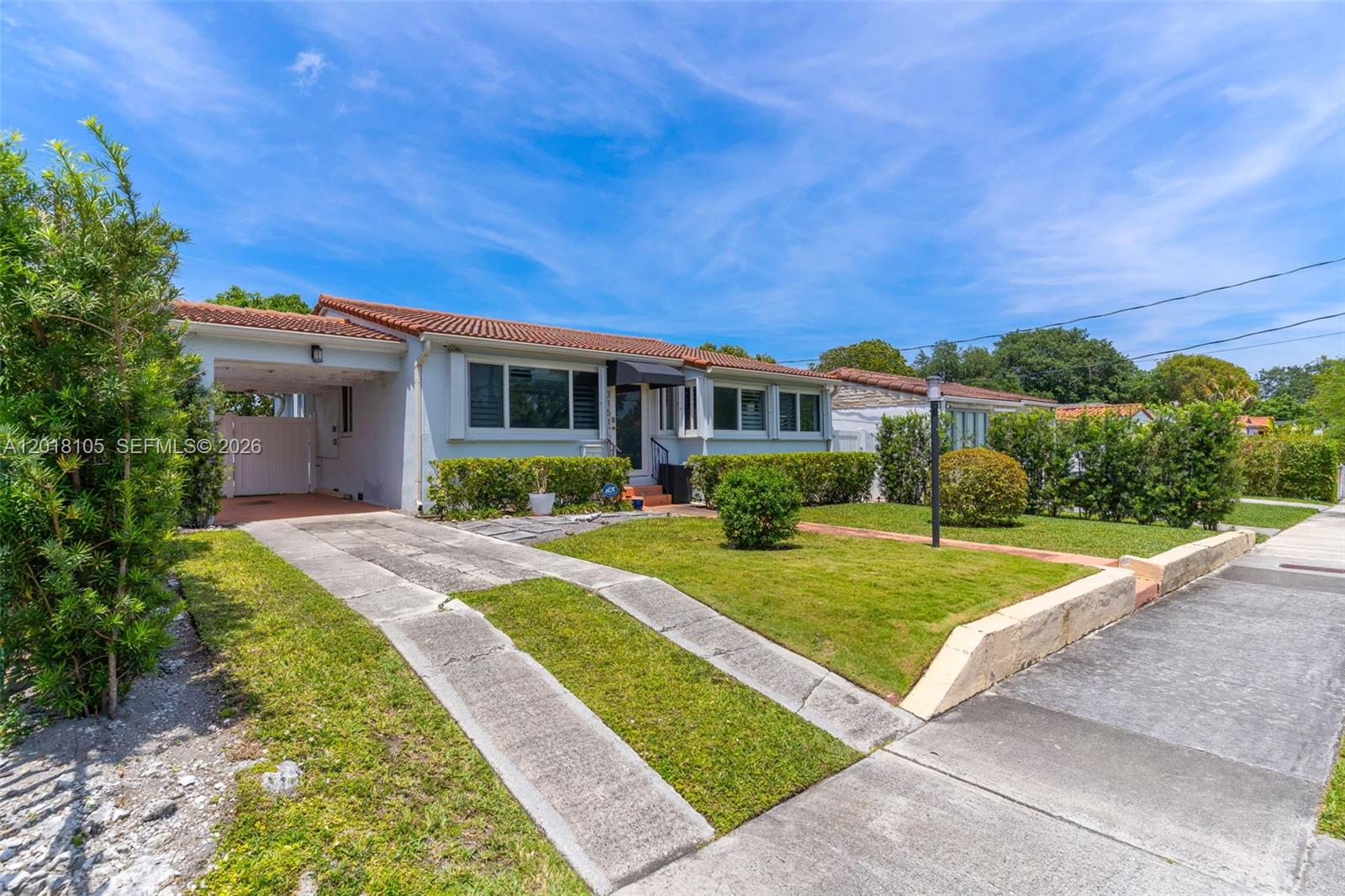 A single-story house features a tiled roof, a carport, and a front lawn — 3151 NW Flagler Ter, Miami FL 33125, MIAMI, FL