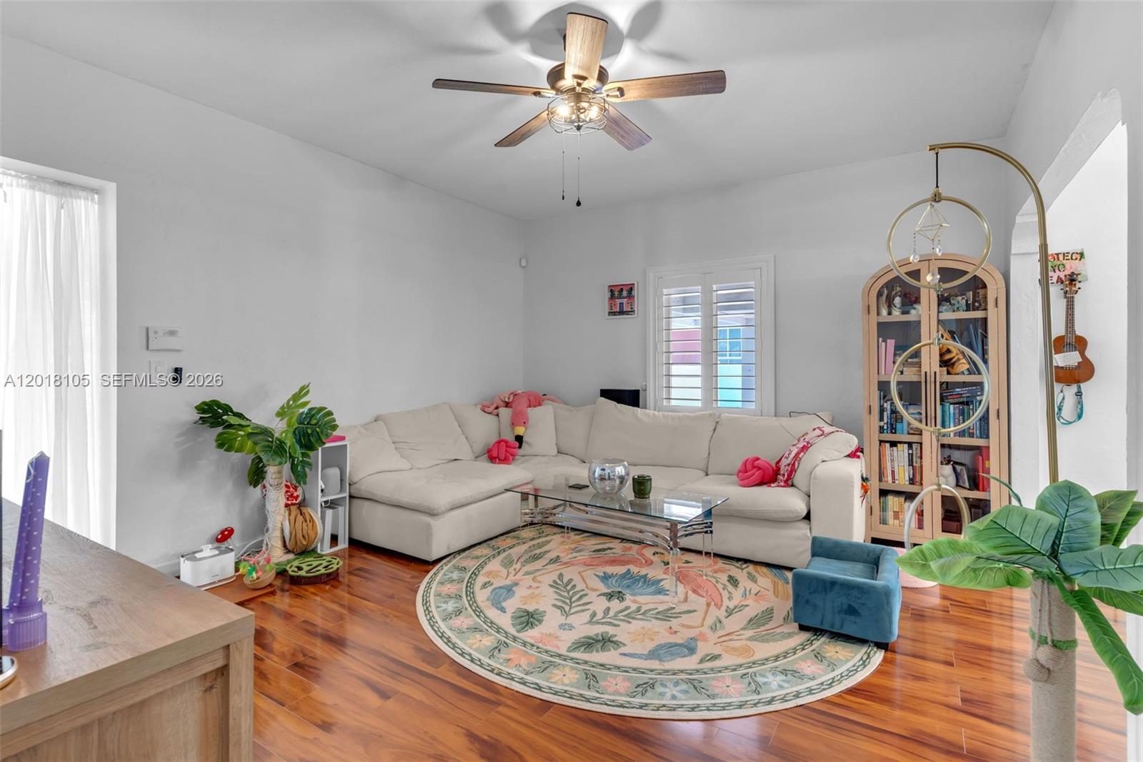 A living room features a white sectional sofa, a round patterned rug, and hardwood floors — 3151 NW Flagler Ter, Miami FL 33125, MIAMI, FL