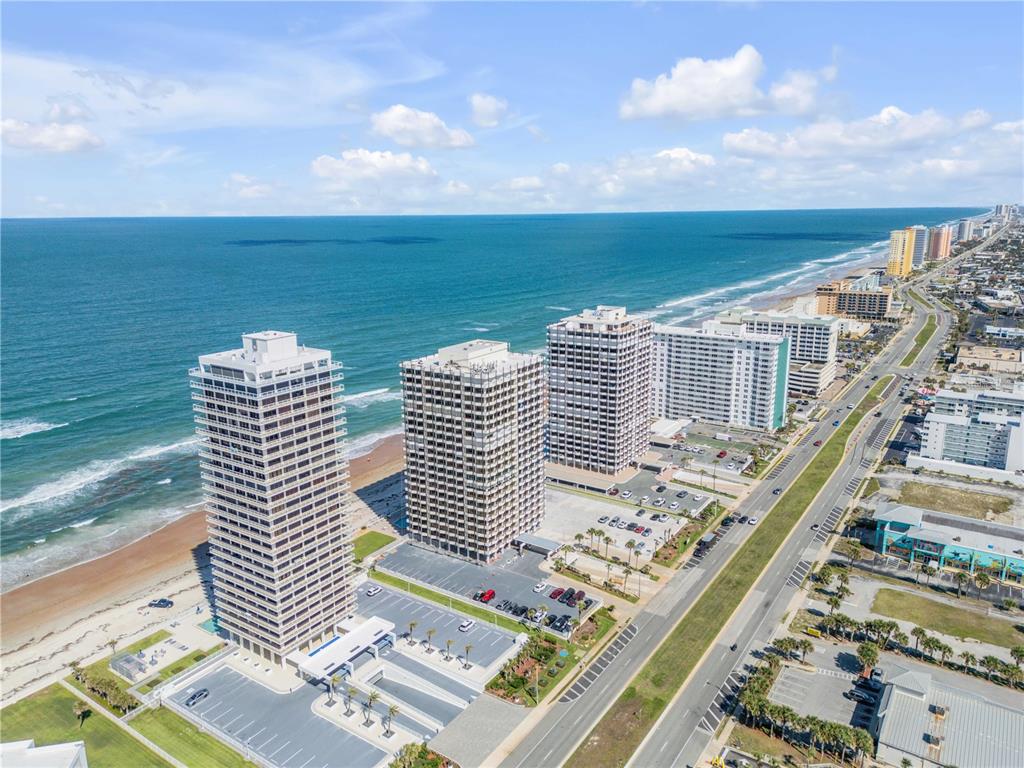 An aerial view shows several high-rise oceanfront condominiums along a sandy beach and coastal highway — 2900 N ATLANTIC AVENUE UNIT 2106, DAYTONA BEACH, FL
