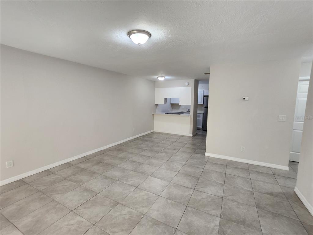 An open-concept living area features light gray walls, large gray floor tiles, and a kitchen — 5200 SE 31ST STREET UNIT 1-4, OCALA, FL