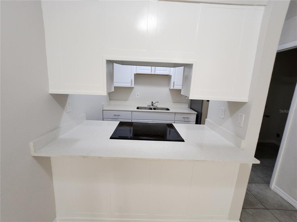 A kitchen features white cabinets, a white countertop, and a black electric cooktop — 5200 SE 31ST STREET UNIT 1-4, OCALA, FL