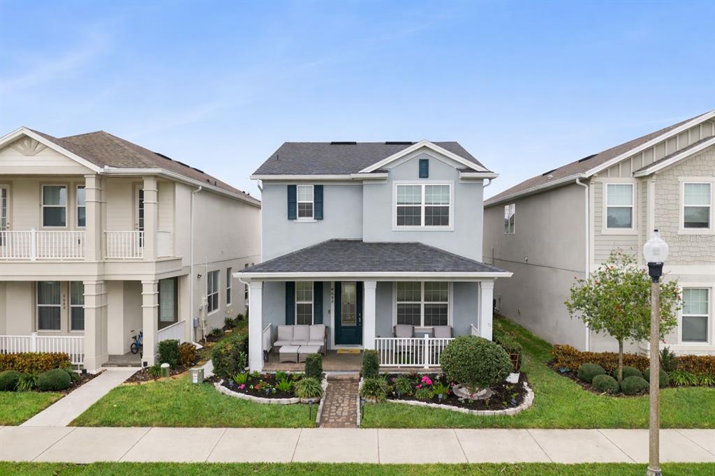 A two-story light blue house with a front porch and a small landscaped yard — 4642 PRAIRIE CREEK STREET, WINTER GARDEN, FL