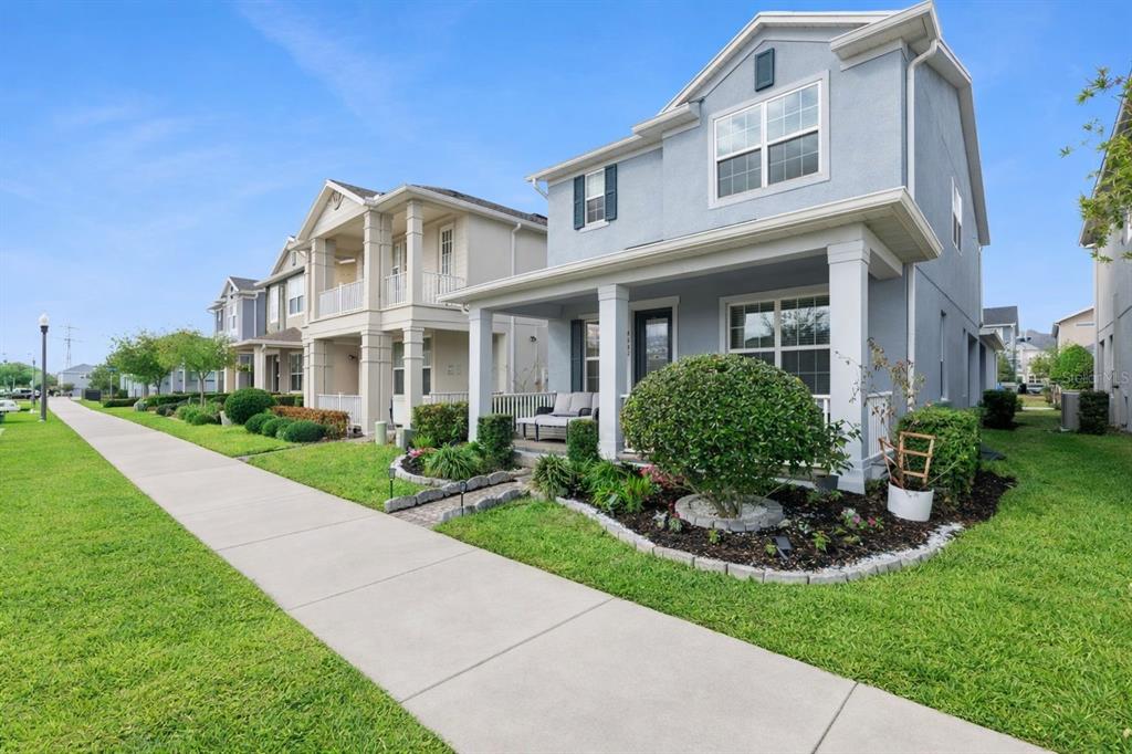 A light blue two-story house with a front porch and a sidewalk in the foreground — 4642 PRAIRIE CREEK STREET, WINTER GARDEN, FL