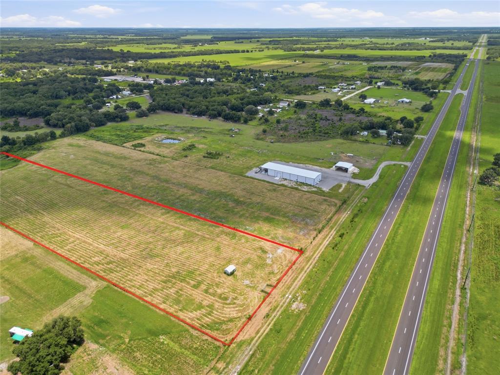 An aerial view shows a rectangular plot of land outlined in red next to a highway — S US HWY 17, ZOLFO SPRINGS, FL
