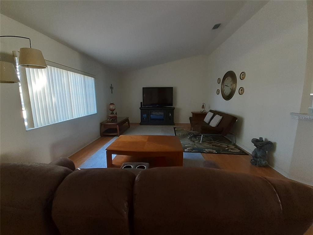 A living room features a brown sofa, a wooden coffee table, and a television console — 11655 SW 140TH LANE, DUNNELLON, FL
