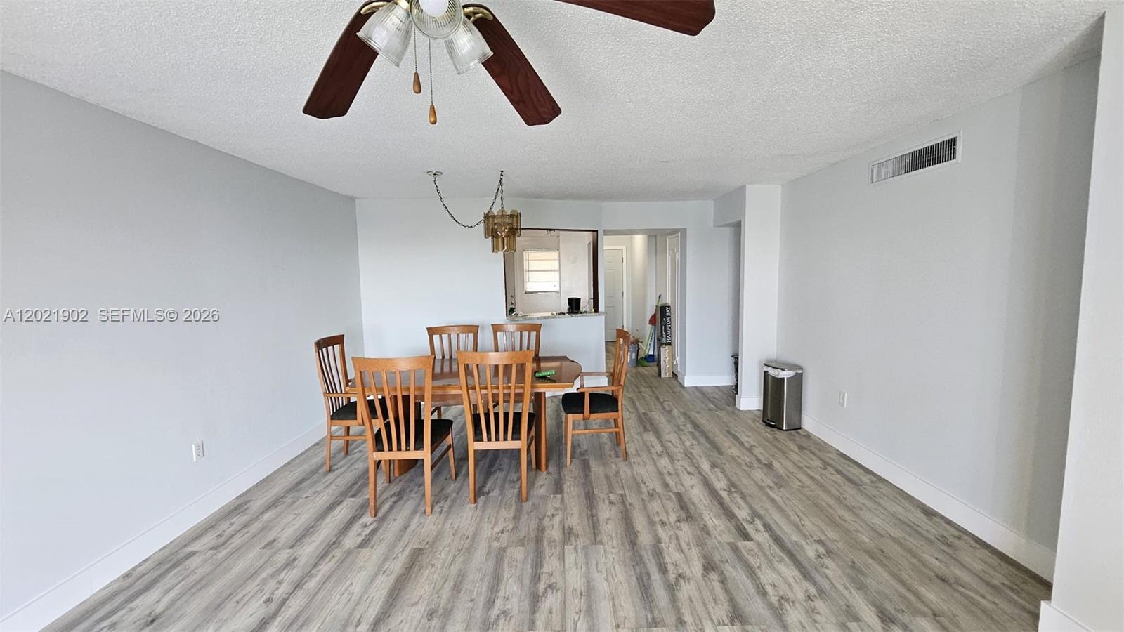 A dining area features a wooden table with six chairs and light wood-look flooring — 1750 NE 191st St # 4, Miami FL 33179, MIAMI, FL
