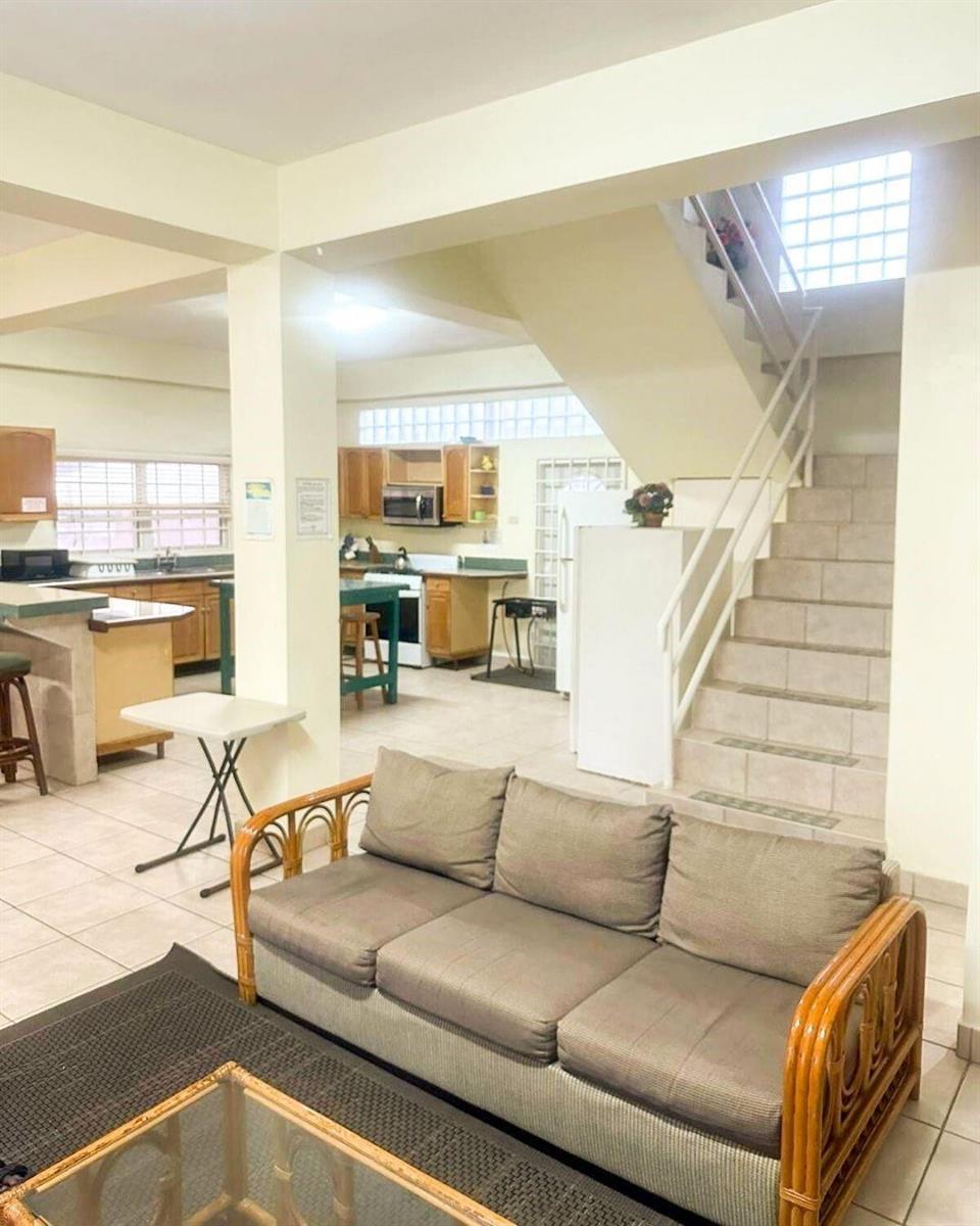 A living area with a sofa faces a kitchen featuring wooden cabinets and tile flooring — LP 53 Lp 53 Gould Street, FL