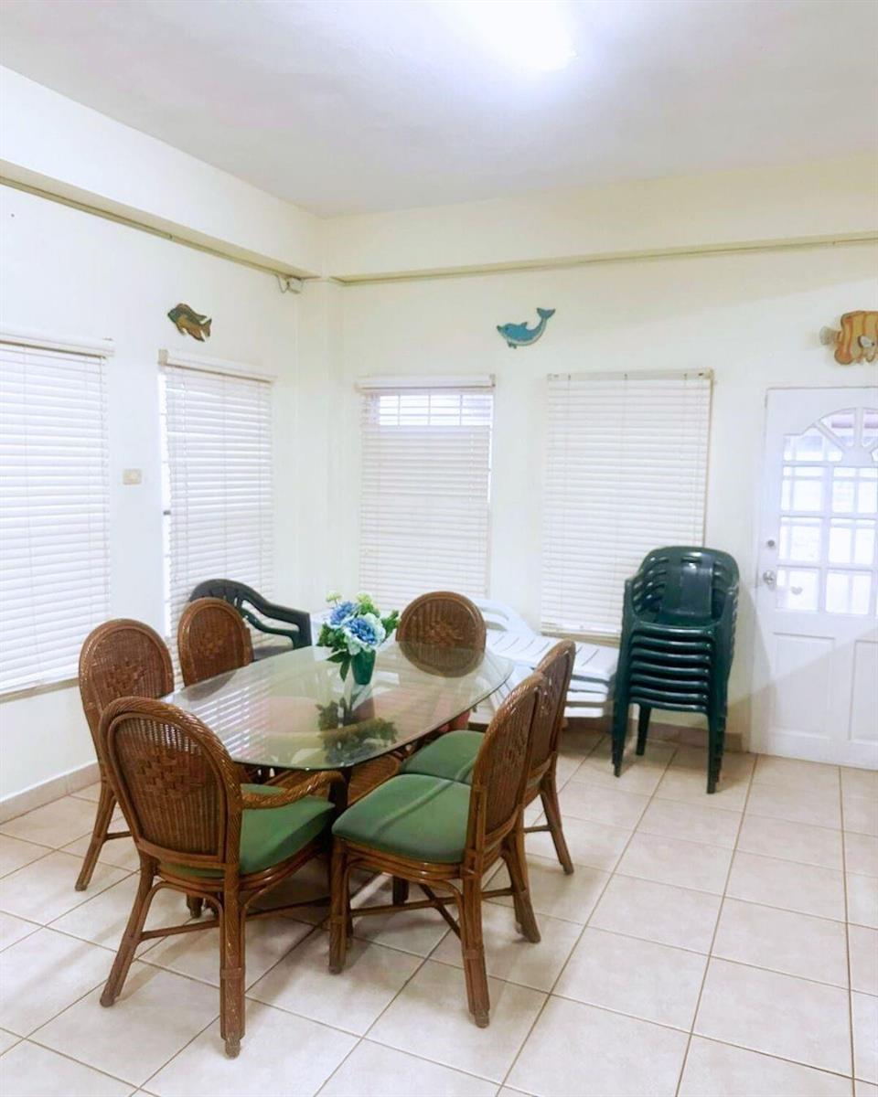 A dining room features a glass-topped table with wicker chairs and tile flooring — LP 53 Lp 53 Gould Street, FL