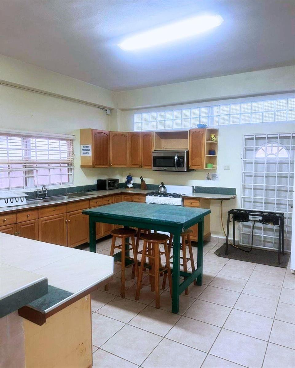 A kitchen features wooden cabinets, a green island with stools, and a white gas stove — LP 53 Lp 53 Gould Street, FL