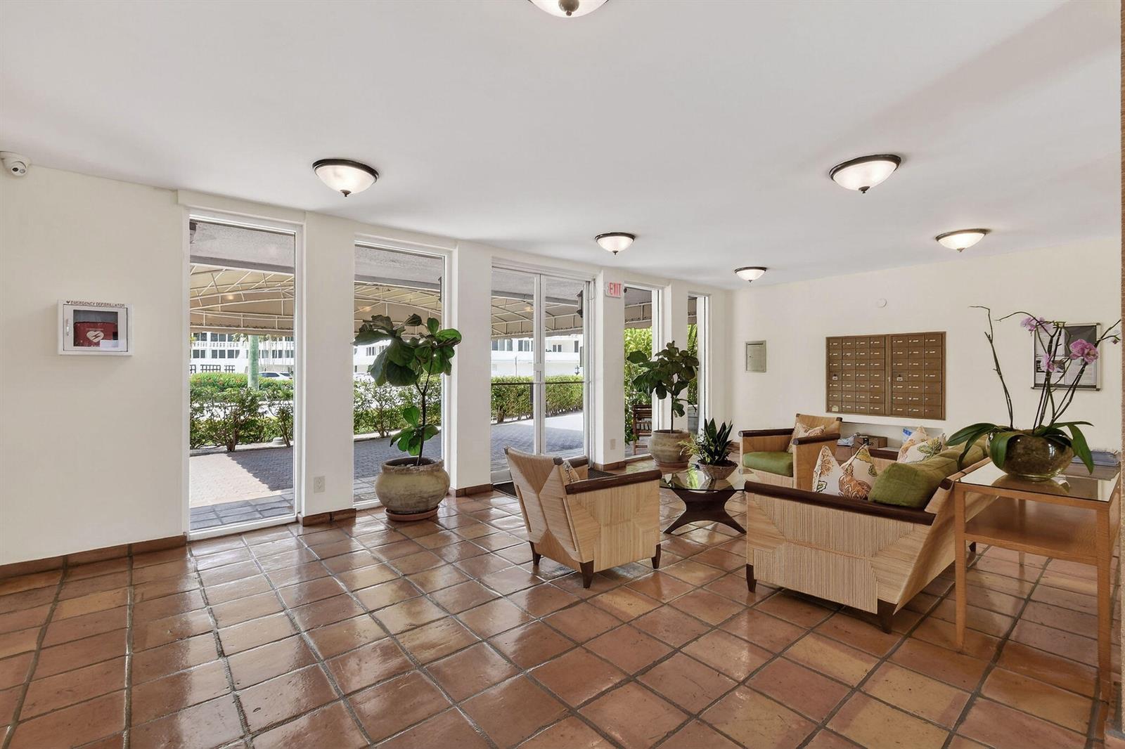 A lobby with tile floors, seating area, mailboxes, and floor-to-ceiling windows looking outside — 139 Sunrise Avenue # 2030, Palm Beach FL 33480, PALM BEACH, FL