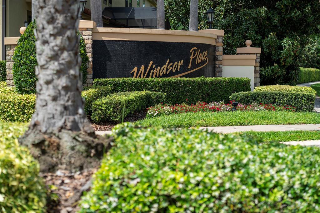 A curved stone and black tile sign reads Windsor Place in front of landscaped hedges — 8439 KELSALL DRIVE, ORLANDO, FL