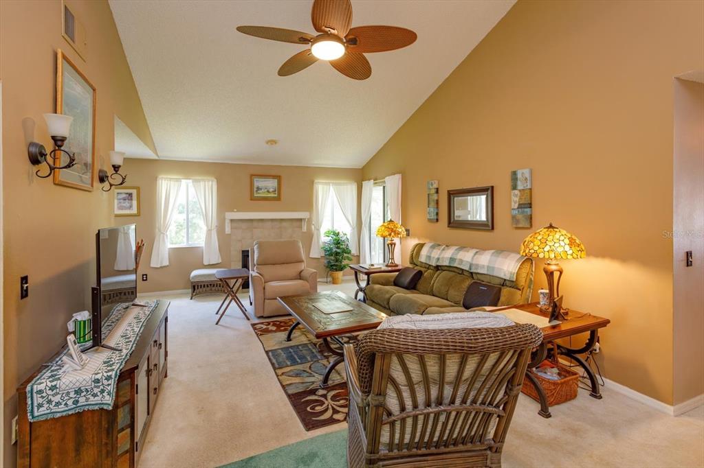 A living room with a vaulted ceiling, a fireplace, and a ceiling fan — 5301 WHITE CLIFF LANE UNIT 7, ORLANDO, FL