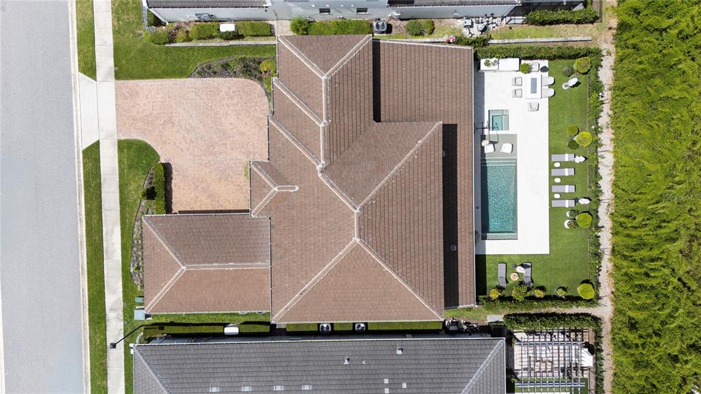 An aerial view shows a house with a brown tiled roof, pool, and paved driveway — 1659 CANYON OAK WAY, SANFORD, FL