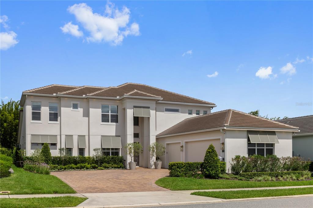 A two-story stucco house with a tiled roof, attached garage, and a paved driveway — 1659 CANYON OAK WAY, SANFORD, FL