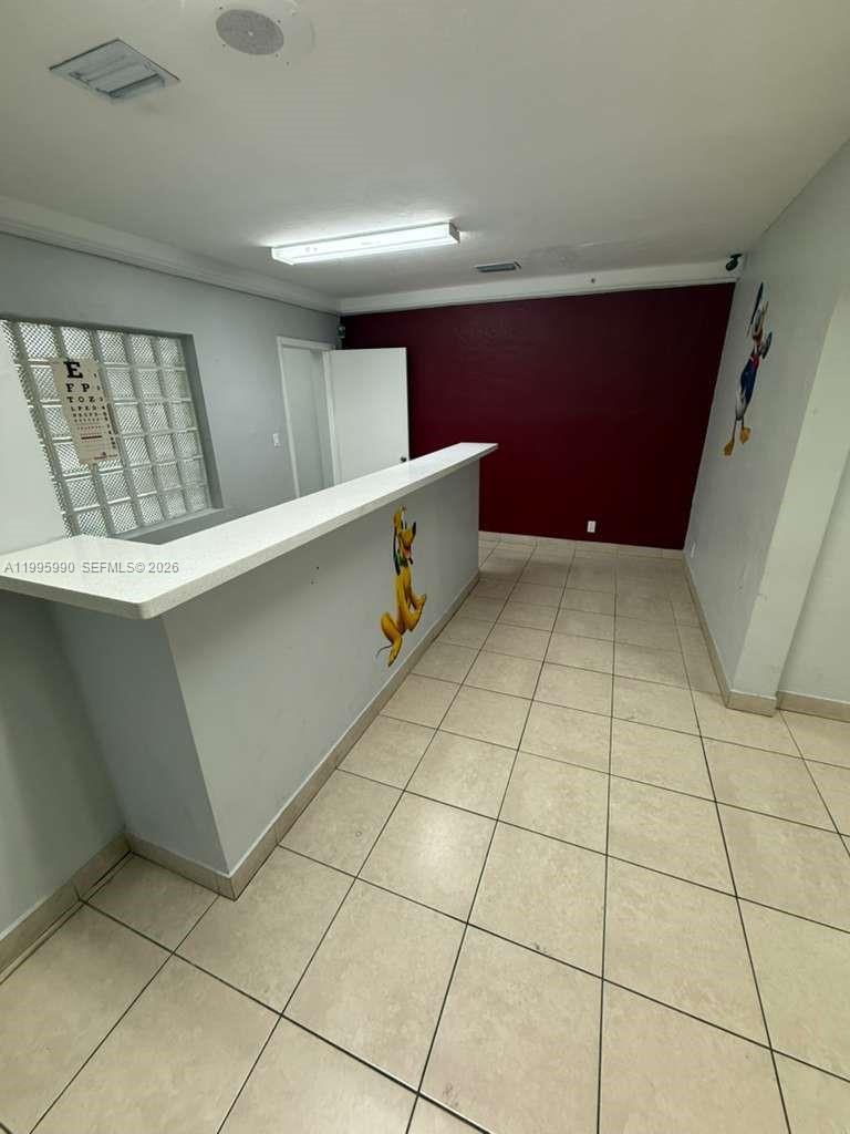 A reception area features a white counter, tiled flooring, and cartoon character wall decals — 4141 SW 6th St, Miami FL 33134, MIAMI, FL