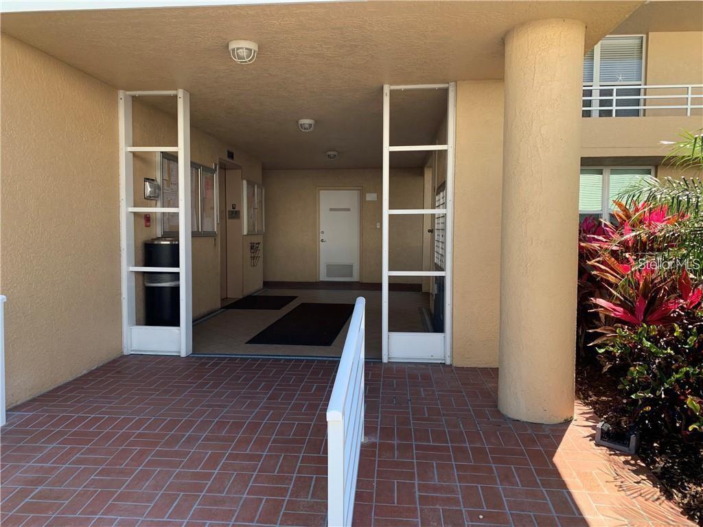 A covered entryway features a brick-paved walkway, white decorative screens, and a central doorway — 4410 FAIRWAYS BOULEVARD UNIT 602-11, BRADENTON, FL