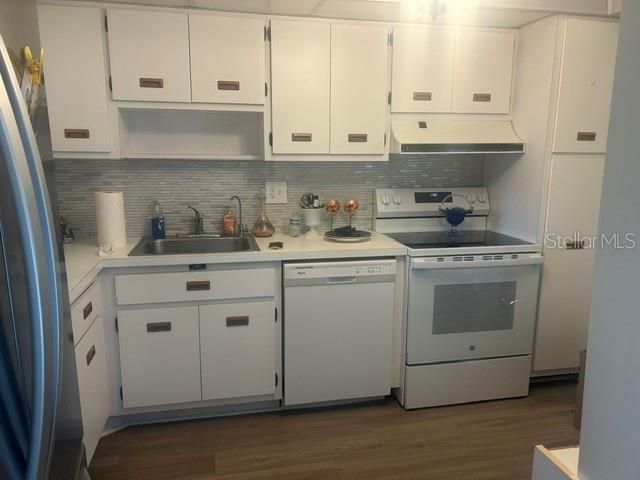 A kitchen features white cabinets, a stainless steel sink, a dishwasher, and a white stove — 7461 W COUNTRY CLUB DRIVE N UNIT 402, SARASOTA, FL