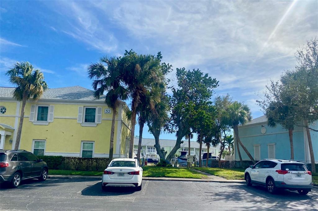 A parking lot sits in front of two multi-story buildings with palm trees between them — 0 NE BEACH DRIVE SE UNIT 95SS, ST PETERSBURG, FL