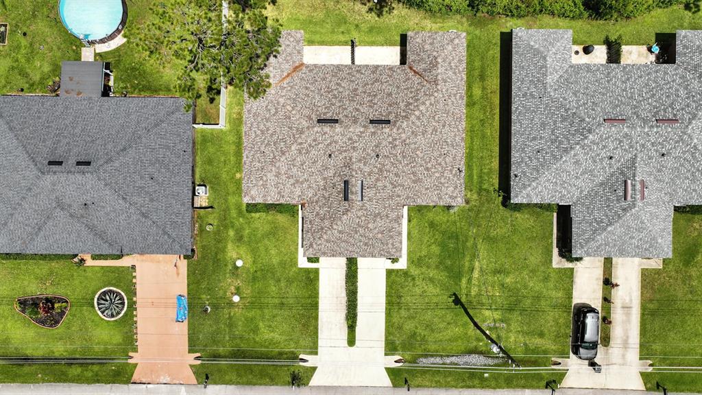 An aerial view shows three suburban houses with driveways and lawns from directly above — 70 RED MILL DRIVE, PALM COAST, FL