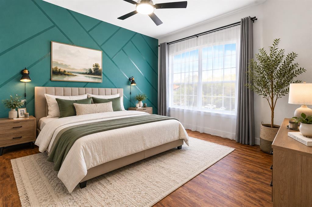 A bedroom features a teal accent wall with geometric trim, a bed, and wood flooring — 18106 PEREGRINES PERCH PLACE UNIT 5302, LUTZ, FL