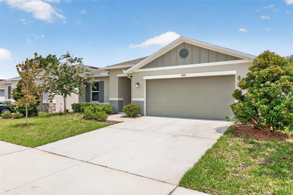 A single-story suburban house with a tan stucco exterior and a two-car garage — 9972 MESIC WOODS AVENUE, SEFFNER, FL