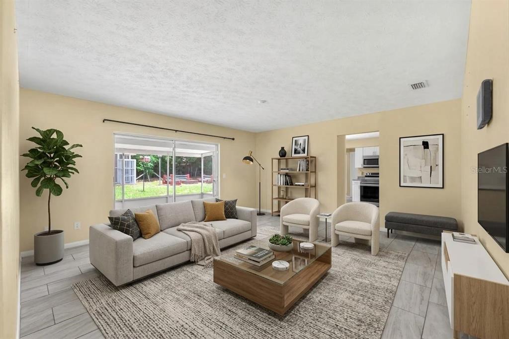 A living room with a gray sofa, two armchairs, a coffee table, and tile flooring — 1909 LIDO DRIVE, BRANDON, FL