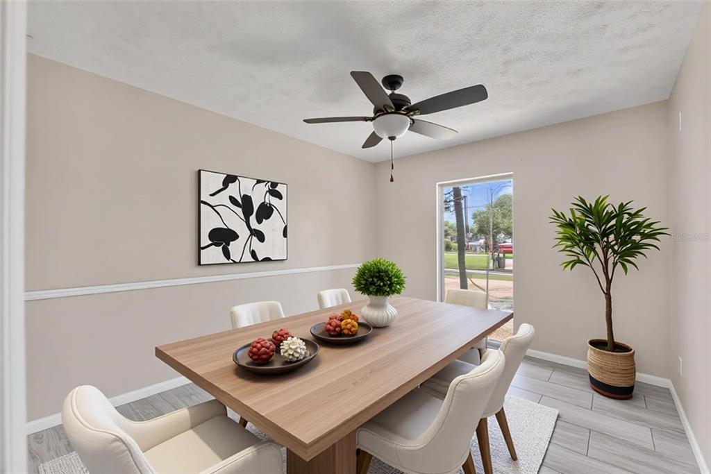 A dining room features a wooden table, white chairs, a ceiling fan, and a potted plant — 1909 LIDO DRIVE, BRANDON, FL