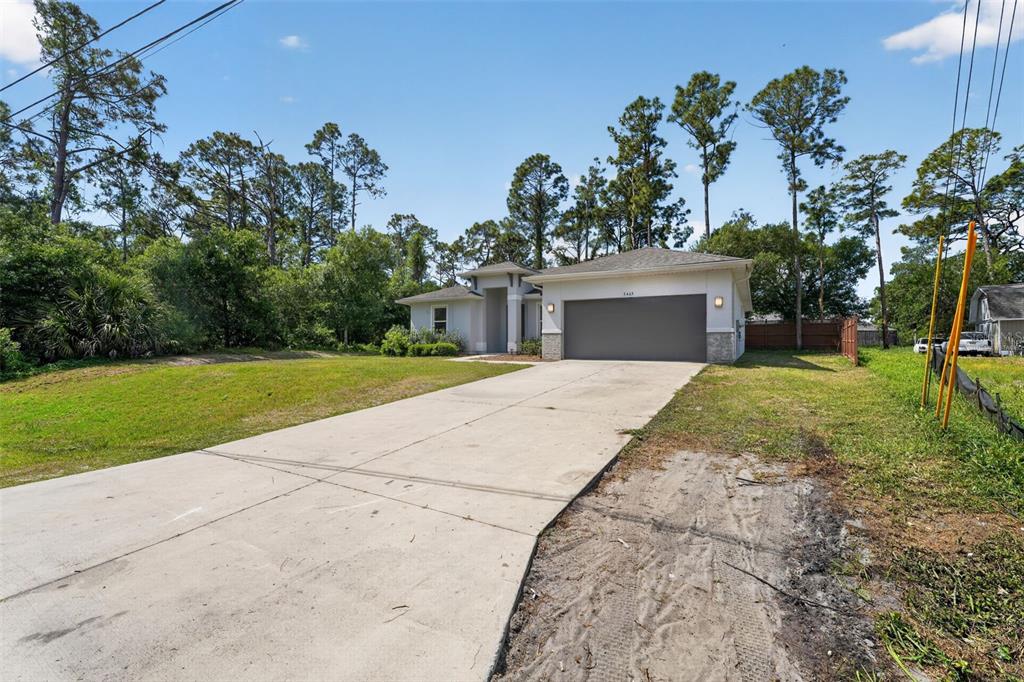 A single-story house with a concrete driveway and a two-car garage sits on a lot — 5465 GAITOR TERRACE, NORTH PORT, FL