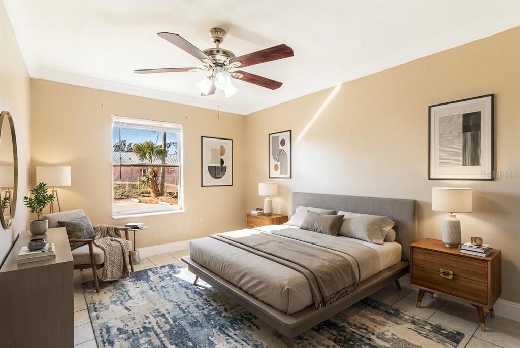 A bedroom features a bed with a gray headboard, a ceiling fan, and a window — 118 OAK CREST DRIVE NW, WINTER HAVEN, FL