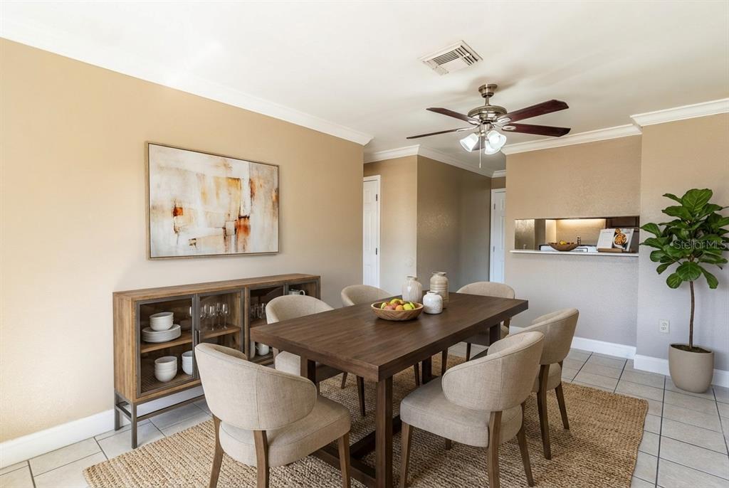 A dining room features a wooden table, six upholstered chairs, a sideboard, and a ceiling fan — 118 OAK CREST DRIVE NW, WINTER HAVEN, FL
