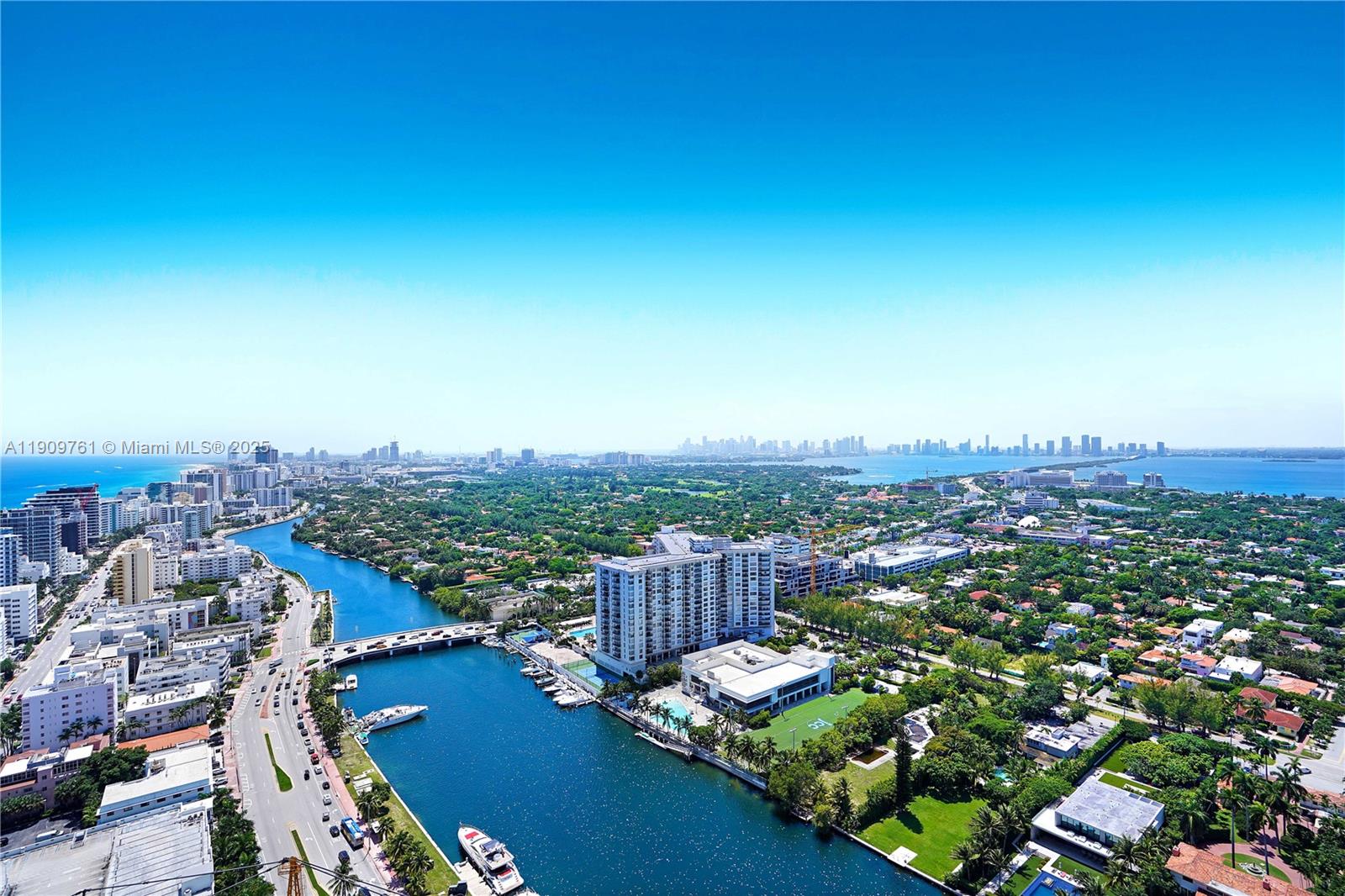 An aerial view shows a waterway, a bridge, residential buildings, and lush greenery in Miami — 4401 Collins Ave, Miami Beach FL 33140, MIAMI BEACH, FL