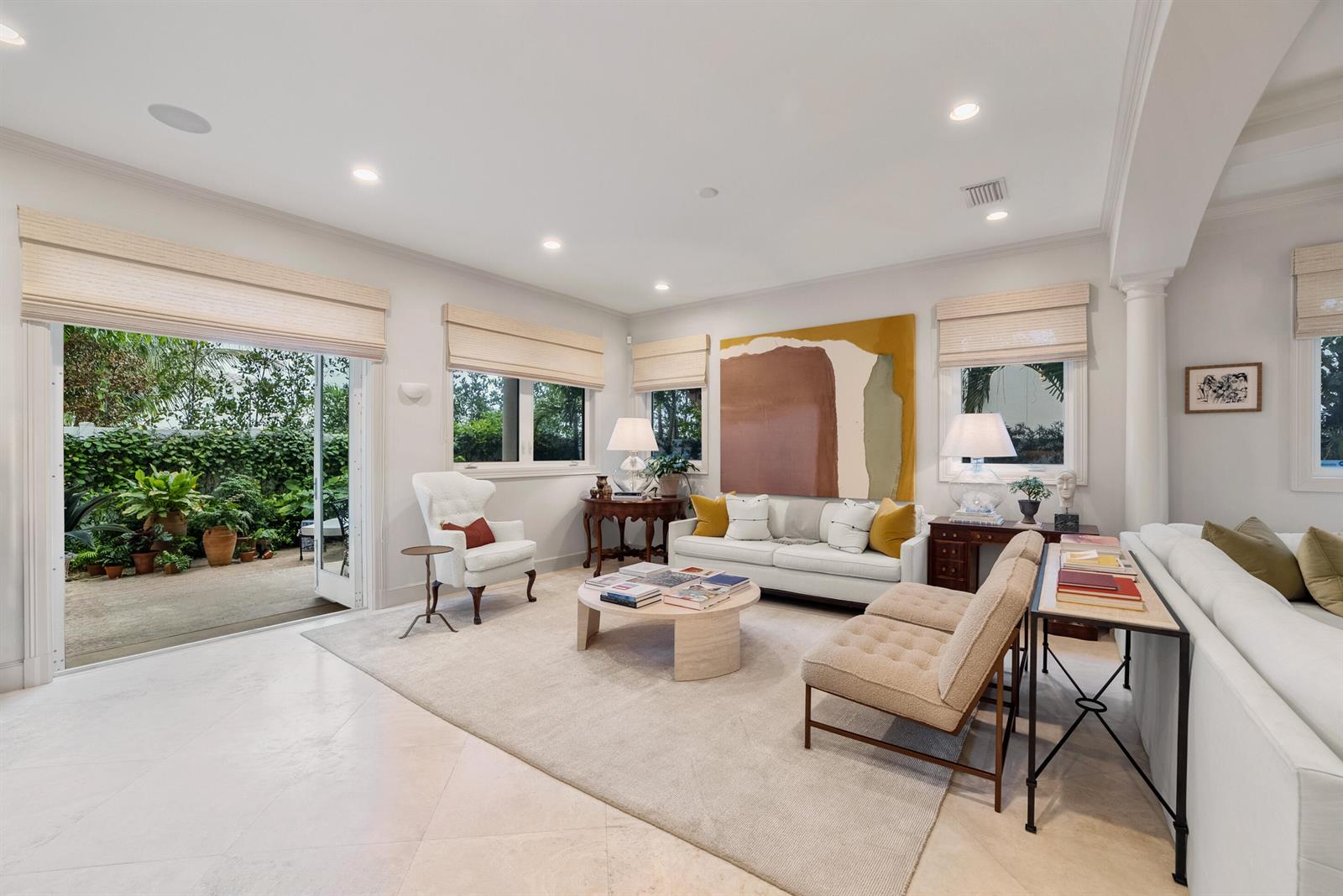 A bright living room features a white sofa, two armchairs, and large glass patio doors — 229 Edmor Road, West Palm Beach FL 33405, WEST PALM BEACH, FL